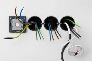 Bruine, blauwe, zwarte en geel-groene stroomdraden bij een elektrische installatie